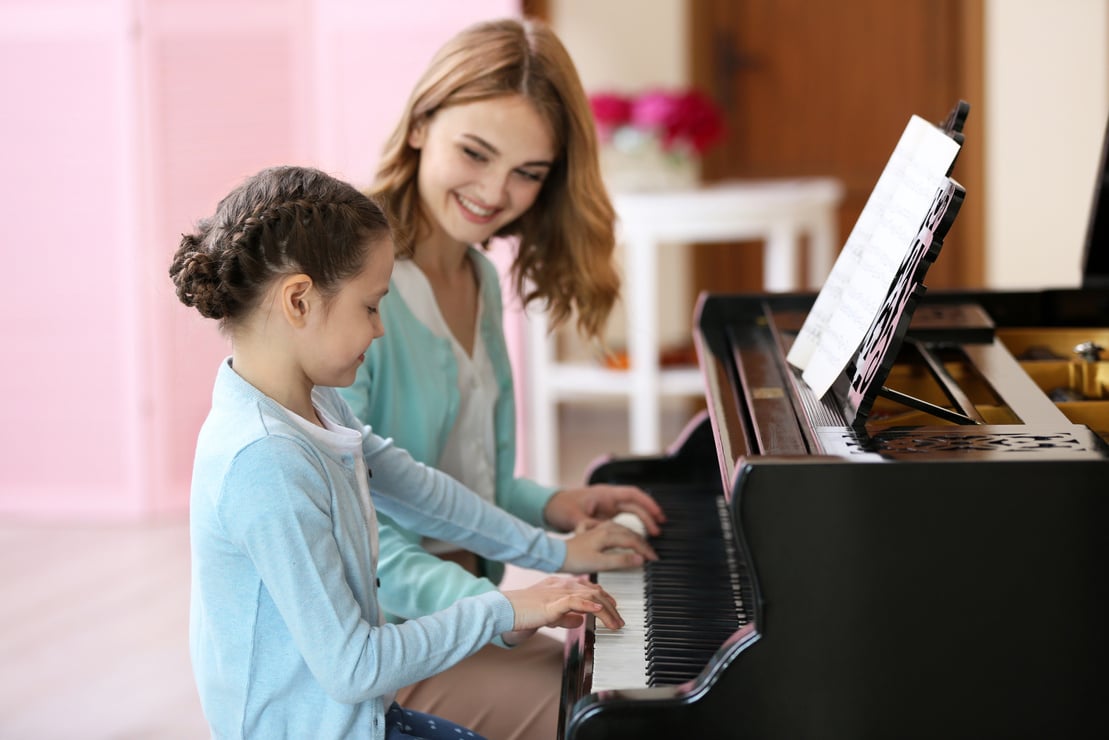 Small Girl  Playing  Piano with Her Teacher