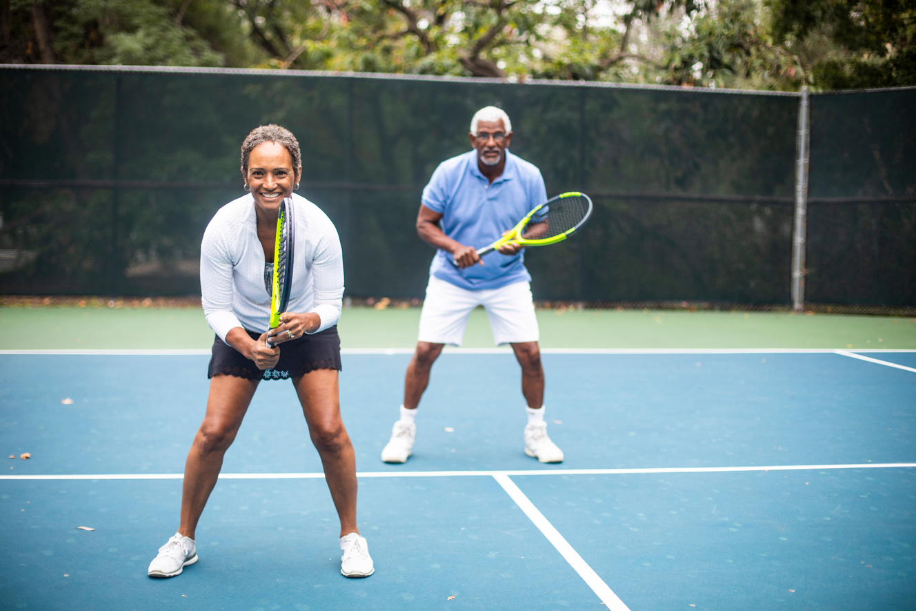 Senior Black Couple Playing Doubles Tennis